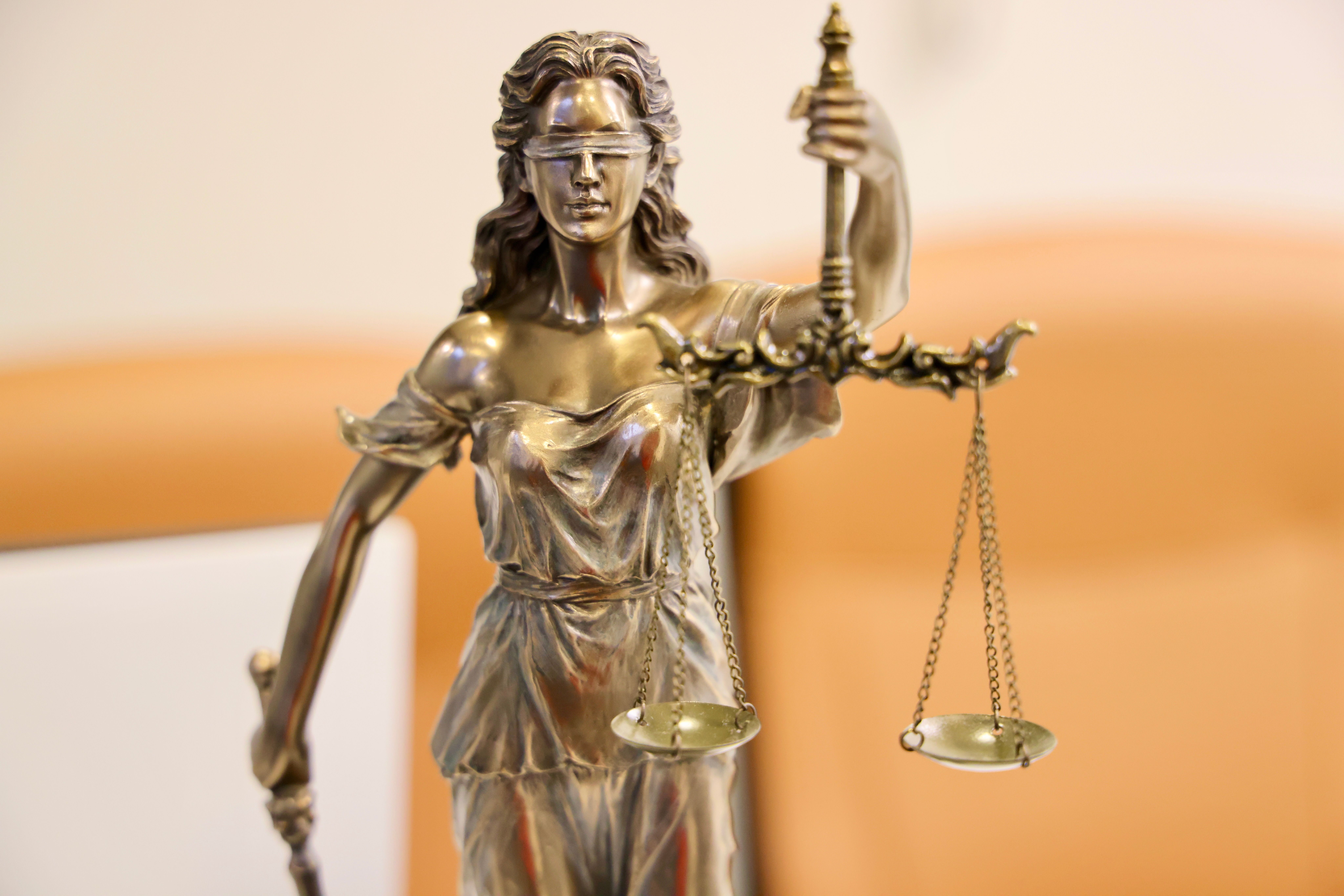 Detailed Lady Justice statue holding scales symbolizing fairness in litigation