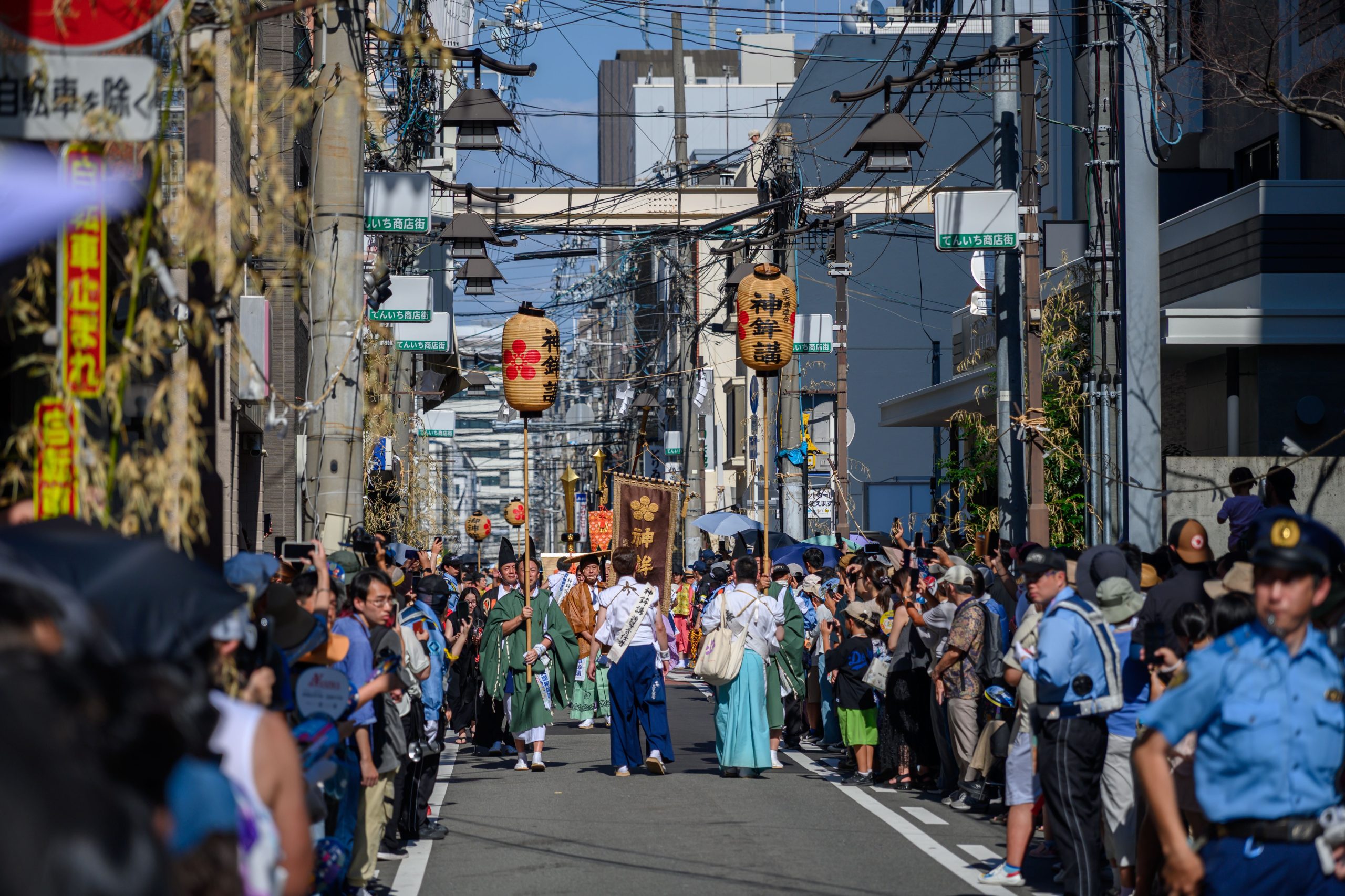 Cultural street festival parade with traditional attire and decorations filling a local town